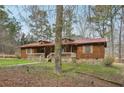Charming single-story home featuring wood siding, a red metal roof, and a cozy front porch at 4009 Highway 138 Sw, Stockbridge, GA 30281