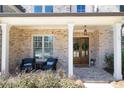 Inviting covered front porch with seating area and brick flooring offers a warm welcome to the home at 3576 Sexton Woods Dr, Chamblee, GA 30341