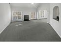 Spacious living room with fireplace, large windows and neutral carpet at 4540 Flat Willow Pl, Douglasville, GA 30135