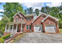 Charming two-story brick home featuring a front porch and two-car garage at 4668 Raiders Ridge Ct, Lithonia, GA 30038