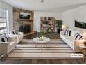 Bright living room featuring a stone fireplace, hardwood floors, and stylish neutral furniture at 4673 Hairston Crossing Way, Stone Mountain, GA 30083