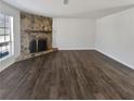 Spacious living room featuring a stone fireplace, hardwood floors, and ample natural light at 4673 Hairston Crossing Way, Stone Mountain, GA 30083