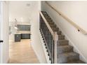 Carpeted staircase with a modern railing located next to an open floor plan kitchen at 724 Shetland Trl, Cartersville, GA 30121