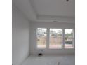 Bright living room featuring tray ceilings and large windows offering views of the surrounding landscape at 2040 Ripple Park Bend, Canton, GA 30114