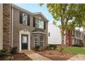 Traditional brick townhome with black shutters and a manicured front lawn at 1843 Grove Way, Hampton, GA 30228