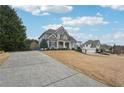 Beautiful home with a long driveway and well-maintained lawn, complemented by lush greenery and a detached garage at 4740 Arbor Meadows Dr, Cumming, GA 30040