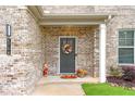 Close-up of front porch with a wreath on the door, decorative flowers and a friendly-looking scarecrow at 4758 Sultana Way, Atlanta, GA 30331