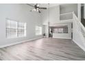 Bright living room with vaulted ceilings, ceiling fan, and stairs leading to a second floor at 613 Woodstone Rd, Lithonia, GA 30058