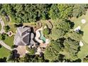 Aerial view of a grand estate with a backyard pool, golf course access, and mature trees at 8480 St Marlo Fairway, Duluth, GA 30097