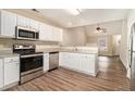 Modern kitchen with stainless steel appliances, granite countertops, and wood grain flooring at 132 Prity Ct, Mcdonough, GA 30253