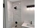 Stylish bathroom with marble-look tile in shower, rain shower head, and modern vanity lighting at 1400 Bouldercrest Rd, Atlanta, GA 30316