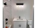 Modern bathroom featuring white marble shower tile, contemporary lighting, and elegant black fixtures at 1400 Bouldercrest Rd, Atlanta, GA 30316