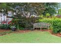 Secluded backyard nook with wooden bench seat surrounded by lush plantings at 1518 Cambridge Ave, Atlanta, GA 30337