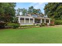 A well-maintained home featuring a lush green lawn, charming porch and mature trees at 1518 Cambridge Ave, Atlanta, GA 30337