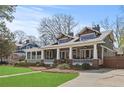 Beautiful two-story home with a large covered porch, manicured lawn, and stylish architectural details at 1518 Cambridge Ave, Atlanta, GA 30337