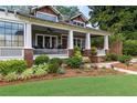 Beautiful home boasting a spacious front porch with white columns and colorful flower beds at 1518 Cambridge Ave, Atlanta, GA 30337