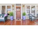 Inviting front porch with hardwood floors, comfortable seating, plants, and College Park Est. 1896 doormat at 1518 Cambridge Ave, Atlanta, GA 30337