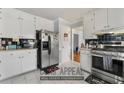 Functional kitchen with stainless steel appliances, white cabinets, and tile backsplash for easy maintenance at 1710 Meadowchase Ct, Snellville, GA 30078