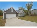 Exterior shot featuring a driveway, garage, and home with pleasant landscaping against a clear blue sky at 92 Fairview Oak Trce, Dallas, GA 30157