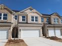 Well-kept townhouse featuring a brick facade, two-car garage, and tidy front yard at 956 Elwood St, Dacula, GA 30019