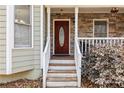 Inviting front entrance with a decorative wood door, stone accents, and painted wood trim at 67 Oak Landing Way, Douglasville, GA 30134