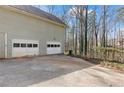 Spacious garage with two bay doors and ample parking space on a concrete driveway at 67 Oak Landing Way, Douglasville, GA 30134