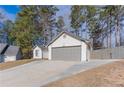 A three-car garage with a driveway and a partial view of the yard and house at 975 Fox Valley Trl, Stone Mountain, GA 30088