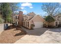 Charming two-story home with an attached garage, complemented by lush greenery and an American flag at 110 Great Oaks Ln, Roswell, GA 30075