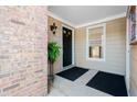 Inviting front porch with a black door, brick accents, and a stylish outdoor light fixture at 110 Great Oaks Ln, Roswell, GA 30075