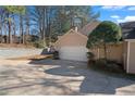 Two car garage with a newly sealed driveway in front of a traditional style, two story home at 110 Great Oaks Ln, Roswell, GA 30075
