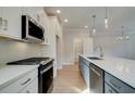 Modern kitchen with stainless steel appliances, white cabinets and a view to the eating area at 4511 Twinberry Dr, Powder Springs, GA 30127