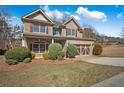 Charming two-story brick home features a well-manicured lawn and an attached two-car garage at 1502 Park Hollow Ln, Lawrenceville, GA 30043