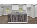 Open-concept kitchen boasts an island with seating, modern white cabinetry, and stainless steel appliances at 2478 Graywall St, Atlanta, GA 30344