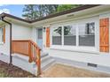 Close-up of the front porch featuring light blue door and stained wood railings and shutters at 2478 Graywall St, East Point, GA 30344