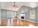 Cozy living room featuring a fireplace, hardwood floors, and a ceiling fan, creating a warm ambiance at 2733 Cedar Tree Ln, Ellenwood, GA 30294