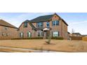 Traditional two-story brick home featuring a meticulously maintained lawn at 821 Bufflehead Ct, Stockbridge, GA 30281