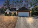 Charming one-story home with a well-maintained lawn and attached two car garage at dusk at 2577 Twin Oaks Sw Dr, Marietta, GA 30064