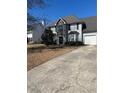 Traditional two-story home with a combination of stone and siding and a paved driveway at 1546 Mine Run, Hampton, GA 30228