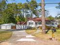 Quaint single-Gathering home with a detached two-car garage surrounded by tall trees at 4100 Brown Rd, Tucker, GA 30084