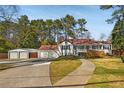 Cozy home with detached garage, a front porch, and driveway surrounded by a large lawn at 4100 Brown Rd, Tucker, GA 30084