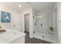 Bright bathroom featuring a spacious glass shower with marble tile, modern fixtures, and decorative floor at 4525 Twinberry Dr, Powder Springs, GA 30127