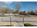 A view of the community center with a large parking lot and mature trees at 5968 Eagle Tiff Ln, Sugar Hill, GA 30518