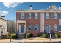 Charming brick townhome with a blue front door, well-maintained landscaping, and symmetrical window design at 5968 Eagle Tiff Ln, Sugar Hill, GA 30518