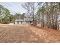 Traditional home with gray siding nestled among mature trees in a serene setting at 2935 Pruitt Rd, Cumming, GA 30041
