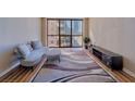Open living room with modern sofa, patterned rug and city views from large windows at 1280 W Peachtree Nw St # 2302, Atlanta, GA 30309