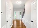 Hallway featuring hardwood floors, wainscoting, and view of front door and staircase at 2540 River Summit Dr, Duluth, GA 30097