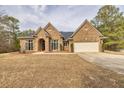 Charming brick home featuring an attached two car garage and a well manicured front lawn and garden at 2915 Pruitt Rd, Cumming, GA 30041