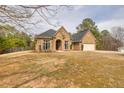 Charming brick home with an arched front entry, well-manicured lawn, and attached garage at 2915 Pruitt Rd, Cumming, GA 30041