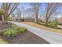 Long driveway leading up to a beautiful brick home with lush landscaping and mature trees at 4755 Huntley Dr, Atlanta, GA 30342