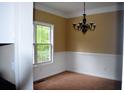 Cozy dining room featuring a classic chandelier, chair rail, and large window at 100 Shoreline Dr, Fayetteville, GA 30215